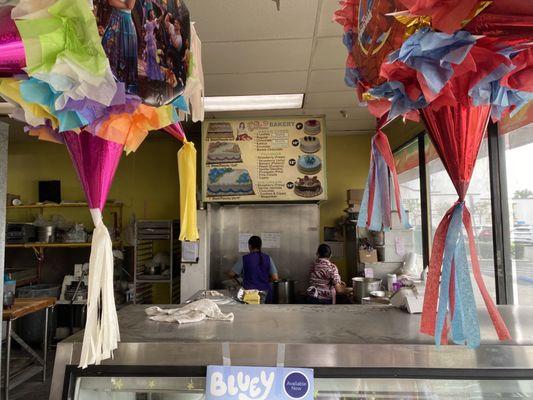 Behind the counter where they are making fresh tamales