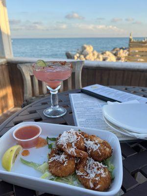 Coconut shrimp and prickly pear margarita on the rocks