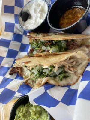 One chicken and one beef birria taco with sour cream, consommé, and guacamole (extra).