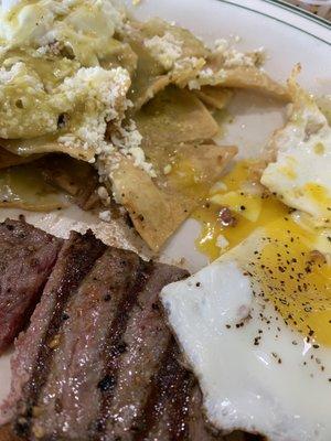 Chilaquiles with sunny side up eggs and rare steak