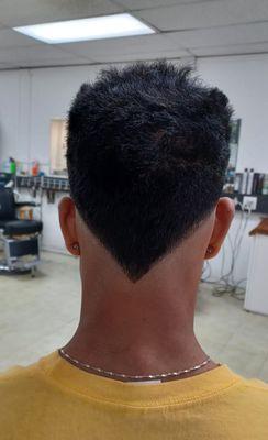 Skin fade, V shape back and spiky top.