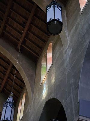 A rainbow of colors sparkle from the stained glass windows high above the floor.