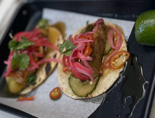 Crispy Pork Belly Tacos with umami caramel, cucumber, cilantro, and chiles.