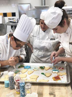 Chef Christina DeLustro and our hardworking students putting together holiday cookie platters!