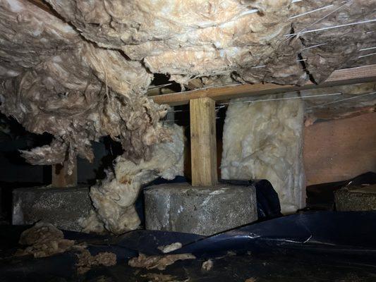 insulation hanging in a crawl space showing the need for crawl space servicing