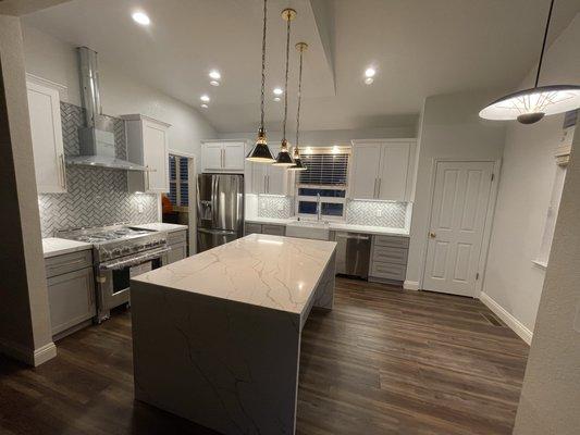 Kitchen remodel, waterfall island Quartz countertops, waterproof luxury vinyl plank flooring.