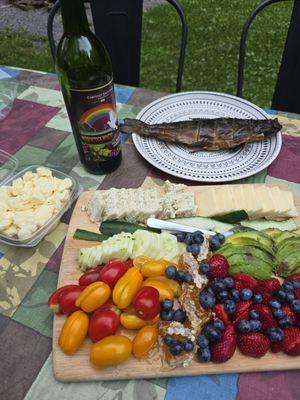 Wine, smoked trout, garlic/dill goat cheese, NY sharp cheddar, cheese curds, cucumber, avocado, grape tomatoes, berries, and honeycomb.