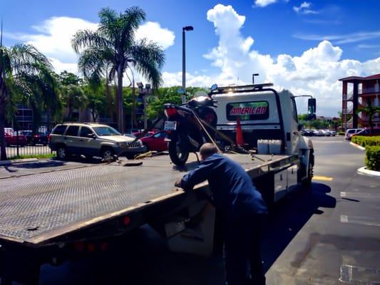 American Towing Service working hard in making sure that this bike is fasten, secured and safe for towing.