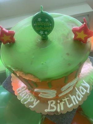 Chipped cake, one coat of green frosting making the orange color transparently seeping through.