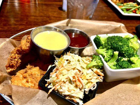 Lunchtime, chicken tenders with coleslaw and broccoli.