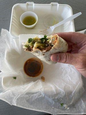 Gonzalez burrito spicy pork and Kearny Asada. With green sauce and a smoked chili sauce.