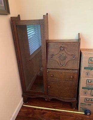 A before picture. Sad wood, wobbly, and single glass cabinet (original old wavy glass) and held up by the Uhaul boxes of China.