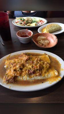 Smothered burrito know as the wet burrito with cheese  also some barbacoa soft tacos and a guac taco