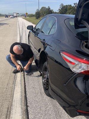 Changing a flat tire on our rental car