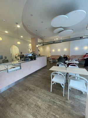 Lots of great table and booth seating. Cute cafe vibes with accents of pink and neutral earth tones. Look at that espresso machine 3