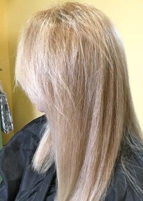 Soft neutral blonde with highlights and slightly angled haircut.