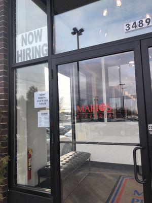 Front  1 2024 now hiring sign  3489 number above entrance