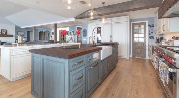 This European style kitchen features contrasting glazed finishes, panelized appliances, and a butcher block CTop on the center of 3 islands.