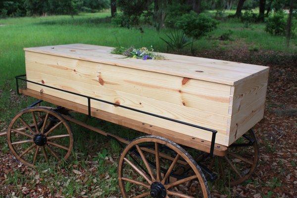 A unfinished wooden casket on our burial cart for a burial at Prairie Creek Conservation Cemetery.