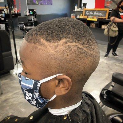 Haircut description: #1 1/2 guard high bald fade with freestyle graphx part.