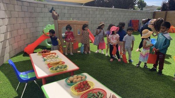 Children are engaged in the farmer's market activity.