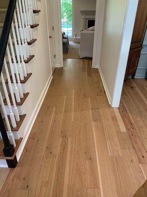 Sand stain and refinish solid hardwood in downstairs to match staircase wood.