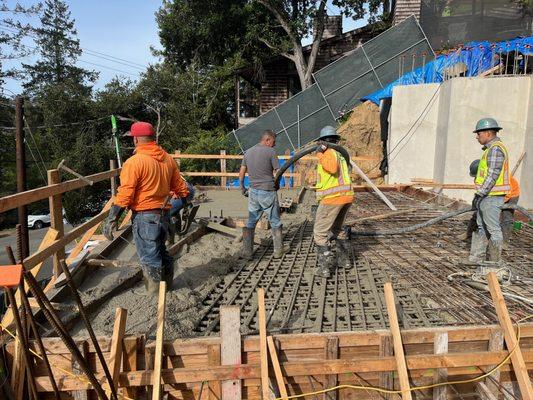 Concrete pouring on uphill 2 story house