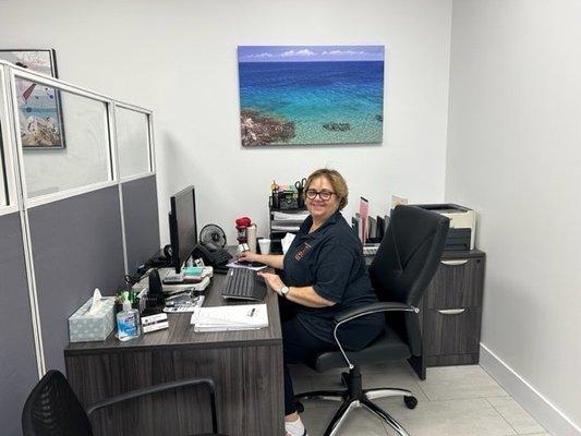 Carmen at her desk in the new office