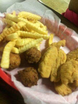 Fried chicken tender basket with hush puppies and fries.