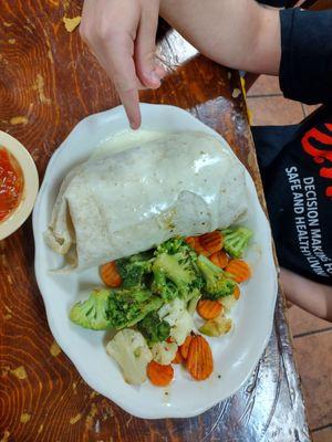 Jumbo burrito next to hand for scale.