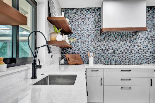 The modern style of the cabinetry and countertops blend perfectly when combined with an artistic backsplash.