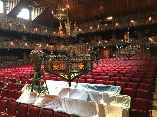 cleaning the chandeliers in the concert hall