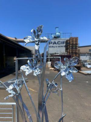 Hand sculpted metal flowers that have just been galvanized