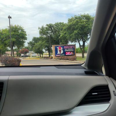 Outside. Picking up lunch in the drive through. Bags of burgers are cheap, but feed a group of people.