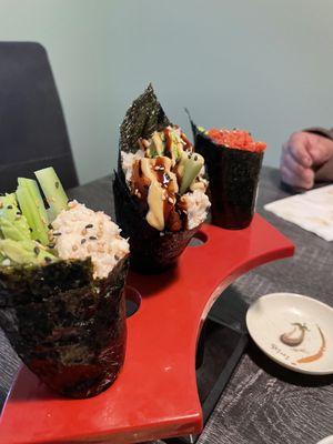 First to the left going to the right  California Hand roll, Tiger Hand roll, & Spicy Tuna Hand roll