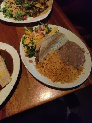 Side dish with taco, salad, rice and beans