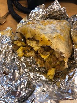 Sausage and egg breakfast burrito with potato and salsa verde