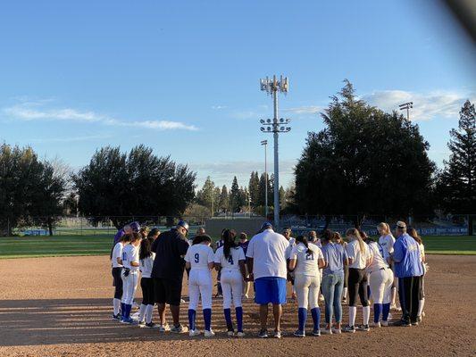 Softball praying with opponent after a game