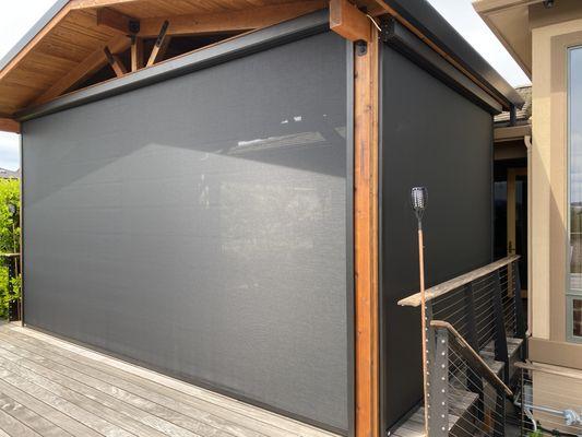 Retractable patio screen. Great for sun protection as well as rain and wind. You can see through fabric when rolled down