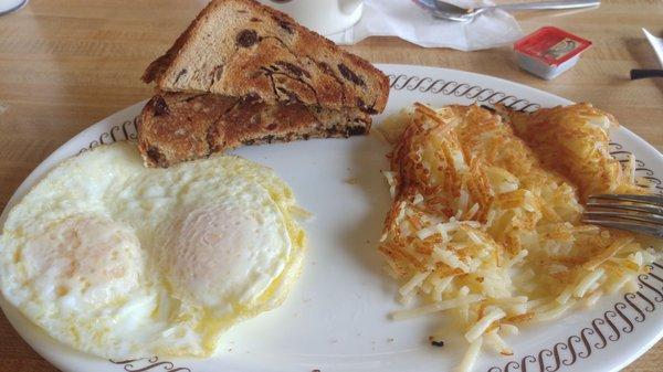 two eggs over medium double or two hash browns raising toast coffee.