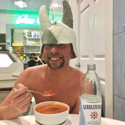 Enjoying delicious Russian Borscht while sporting a traditional banya hat