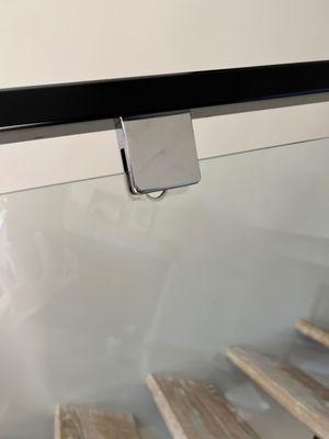 Glass panel on staircase sliding out of the clip that is attached to the handrail.