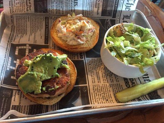 Salmon sandwich topped with guac and slaw