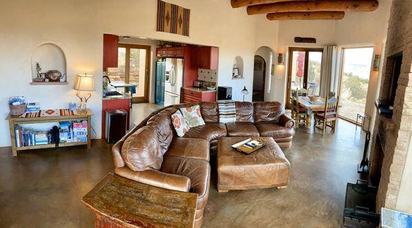 Open living room with comfortable leather couch, fireplace, and panoramic views.