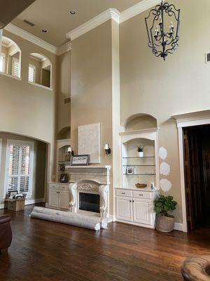 Living room before. No furniture, outdated shelves, lights, color and chandelier.