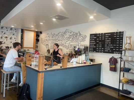 Counter with menu and a cute mural of the town