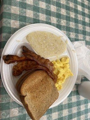 Breakfast combo with eggs, toast, bacon, and grits.