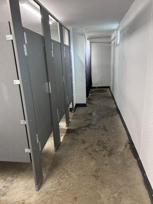 Clean restroom with 3 stalls and 3 showers