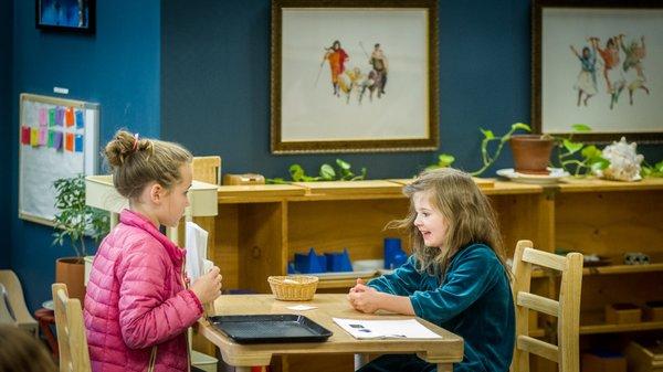 Two Elementary students guide each other through a lesson.