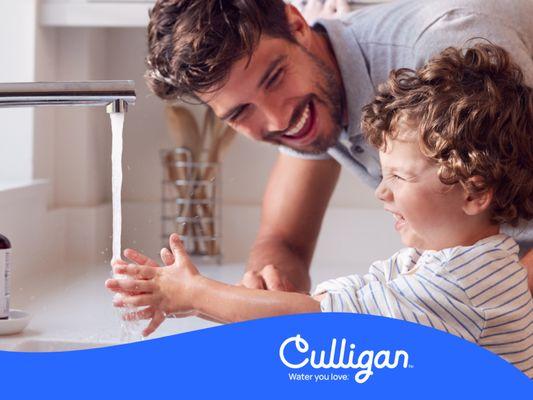 Father and son at sink using Culligan soft water.